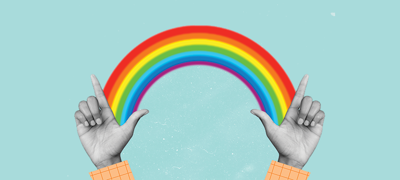 Rainbow background with two hands connecting in the foreground, celebrating Pride and community.
